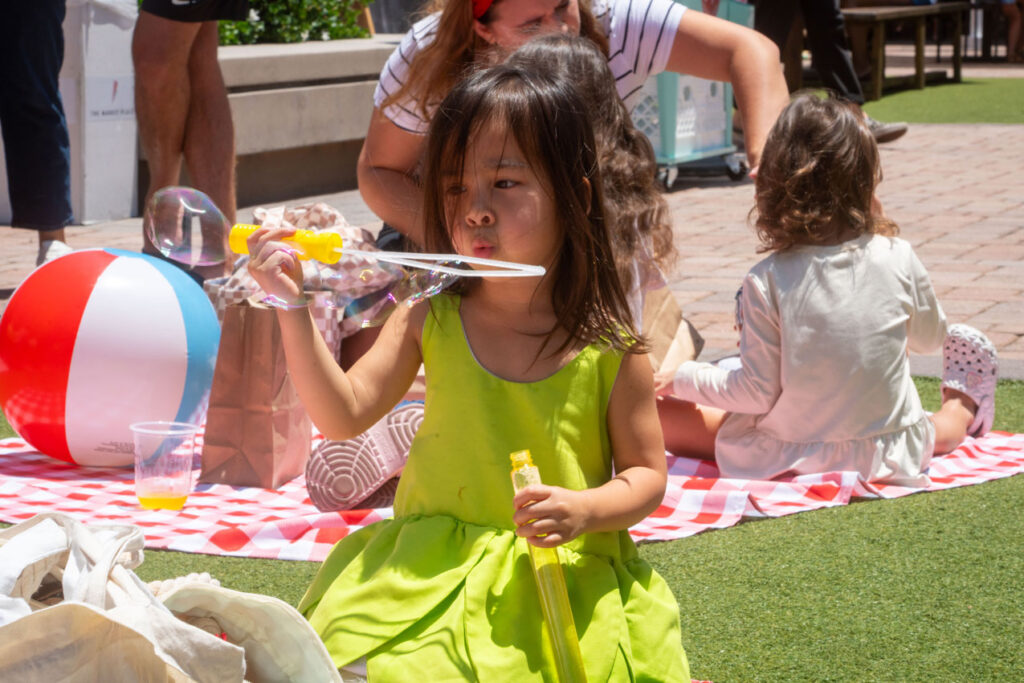 Girl blowing bubbles at The Market Place