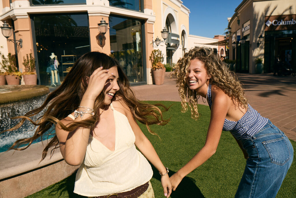 Two girls laughing near the fountain at Irvine Spectrum Center